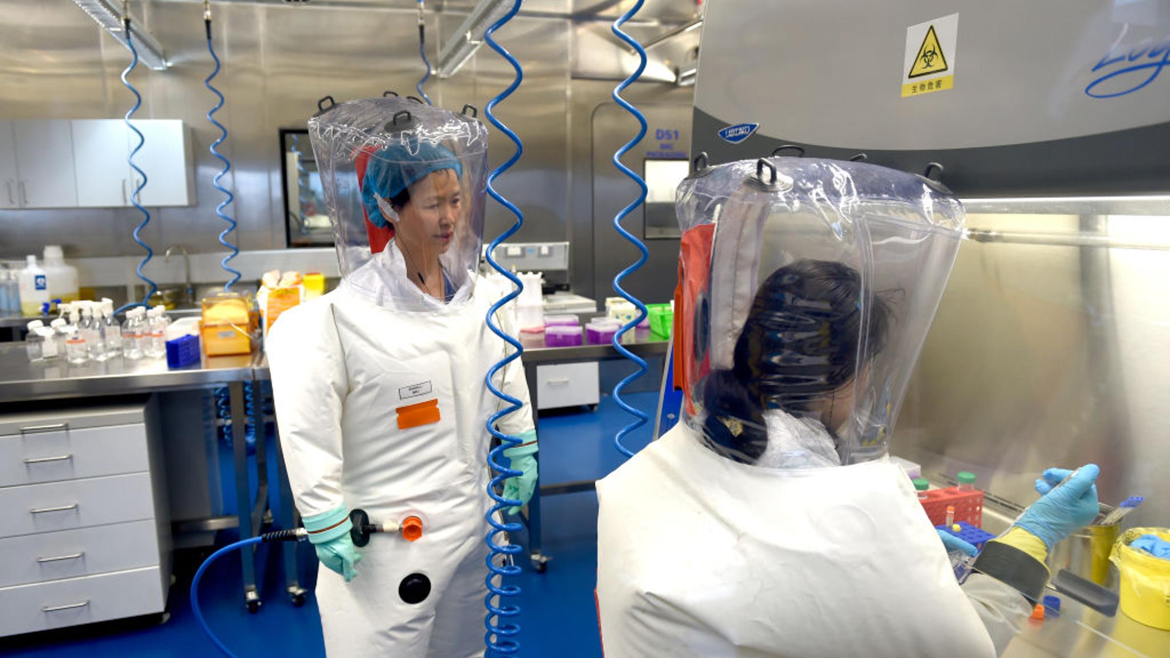 Modern BSL-3 biosafety laboratory with scientists in PPE and advanced equipment